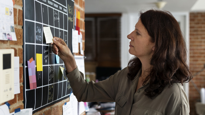 woman taking note off calendar