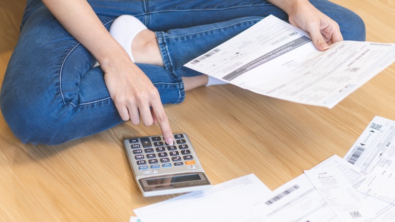 Woman on floor examining invoices