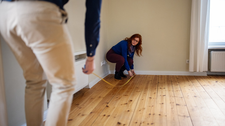 Couple measuring a room