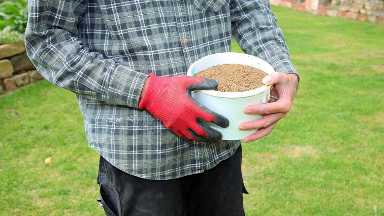 Man holding bucket of seeds