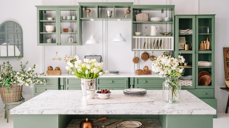 white marble countertop in a sage green kitchen