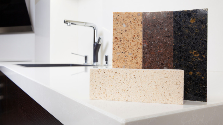 Different quartz kitchen counter top samples on white polished countertop with precise processed edges.