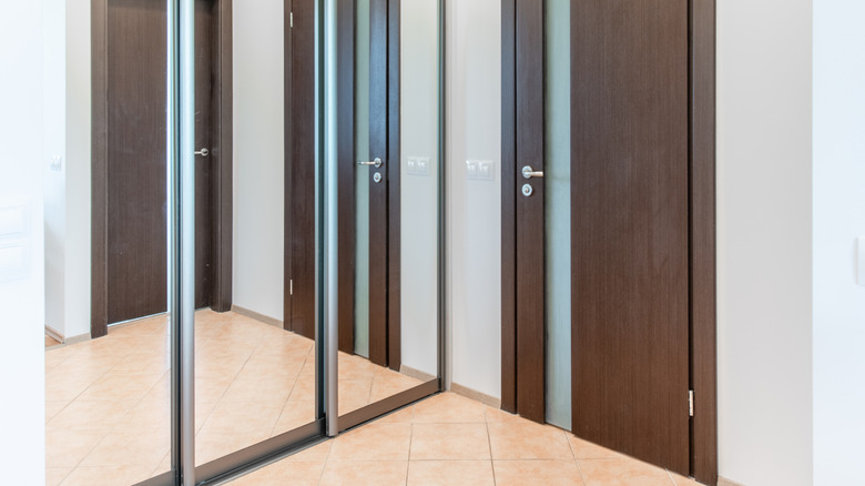 Several mirrored doors reflecting a single wood door