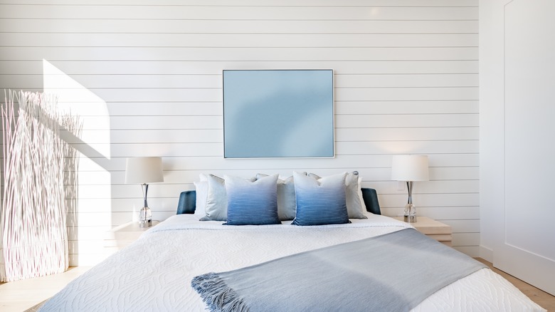 A white bedroom with a shiplap accent wall