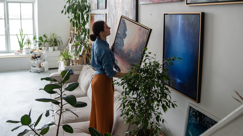 woman hanging up gallery wall