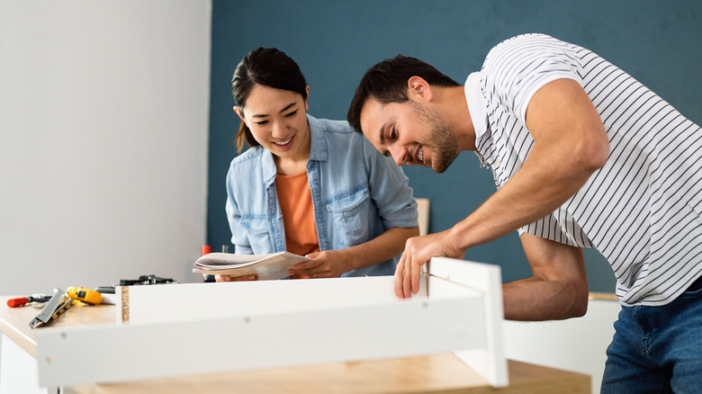 Couple assembling IKEA dresser