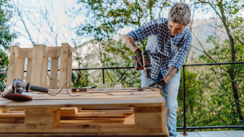 person building wooden pallets outside