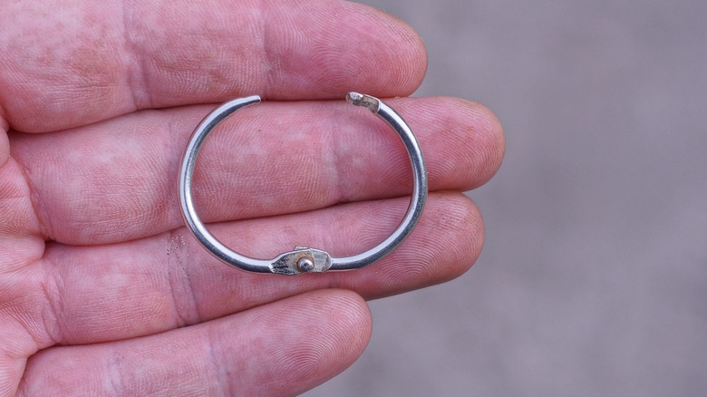 Hand holding metal book ring