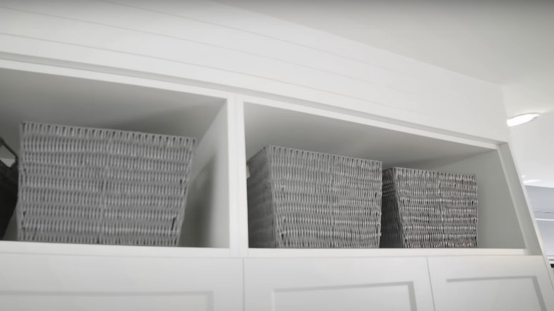 grey wicker baskets on white shelves