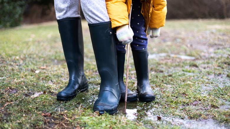 People standing in their muddy backyard