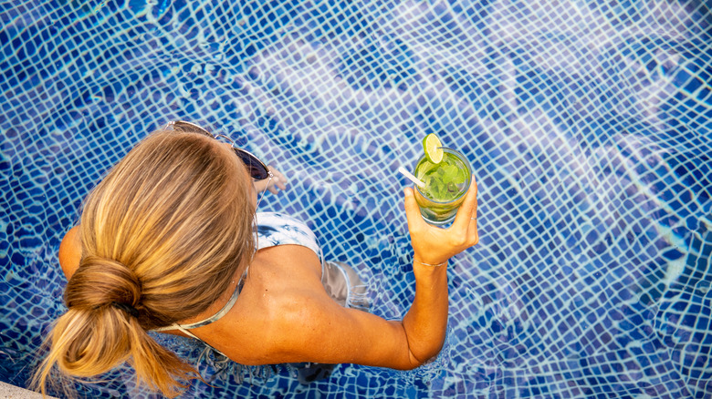 woman relaxing in above-ground pool