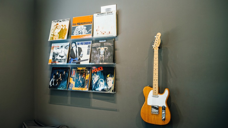 Vinyls displayed on shelves on a black wall