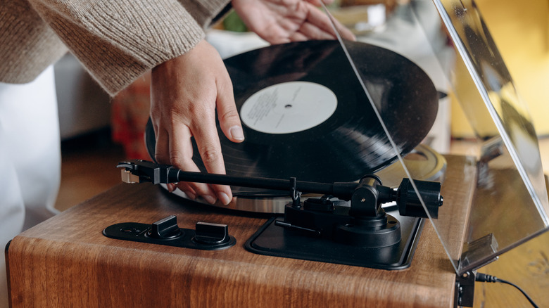 A person putting a vinyl on record player