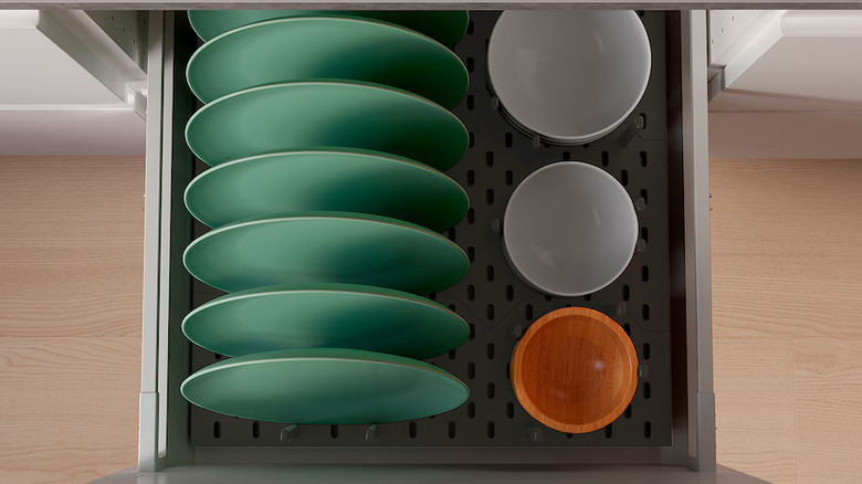 Green and white dishes on peg drawer organizer