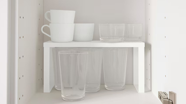 Glasses and white cups on inner shelf