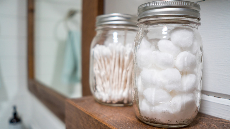 Closeup of two mason jars filled with cotton balls and cotton swabs