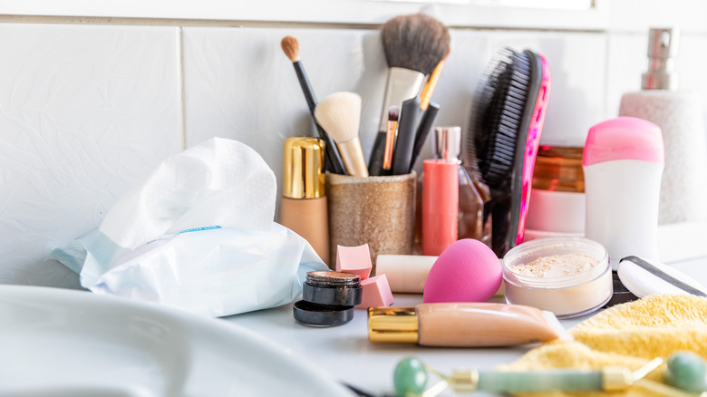 makeup and beauty products cluttering up a bathroom vanity