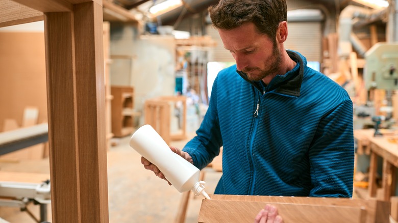 man gluing wooden pieces together