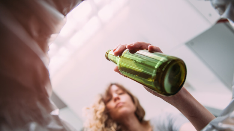 Person throwing away bottle