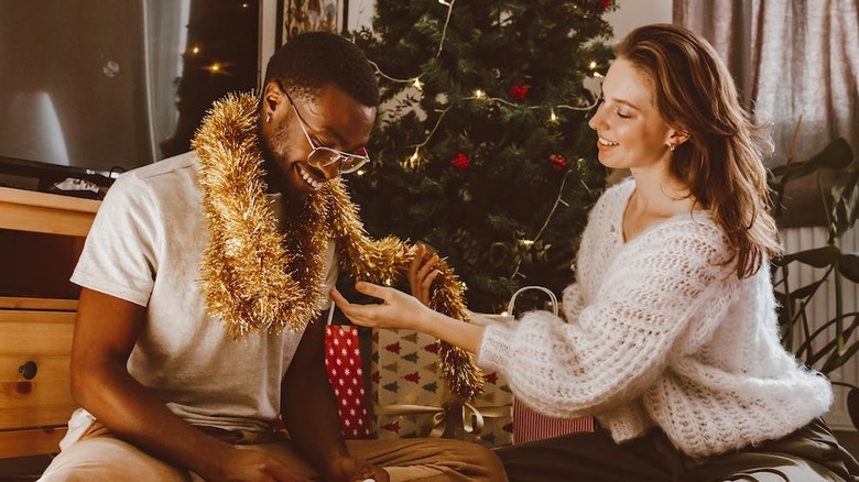 person wrapping garland around partner