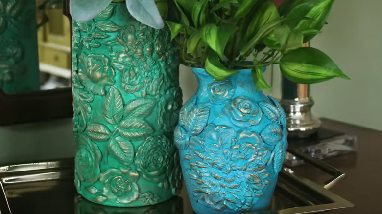 Two hand-crafted Victorian vases on decorative tray.