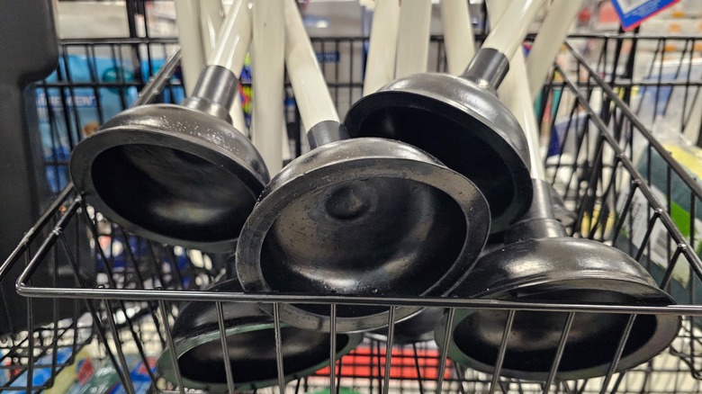 A pile of plungers in a cart