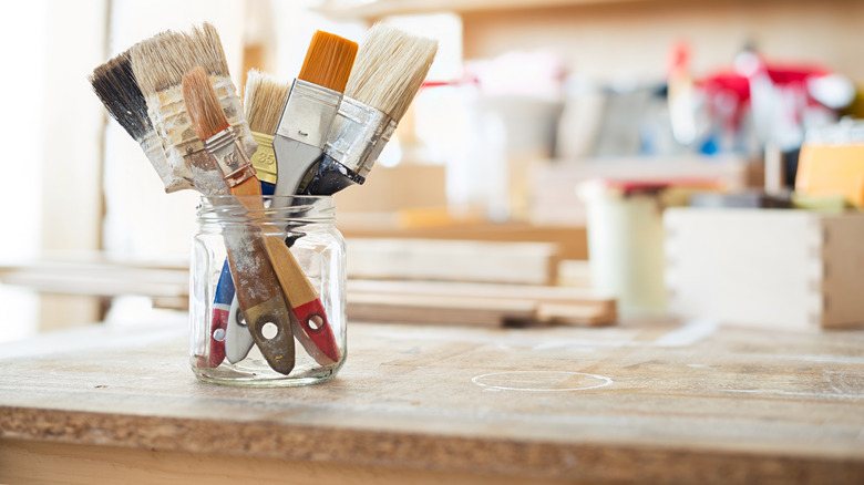 jars with paint brushes on table