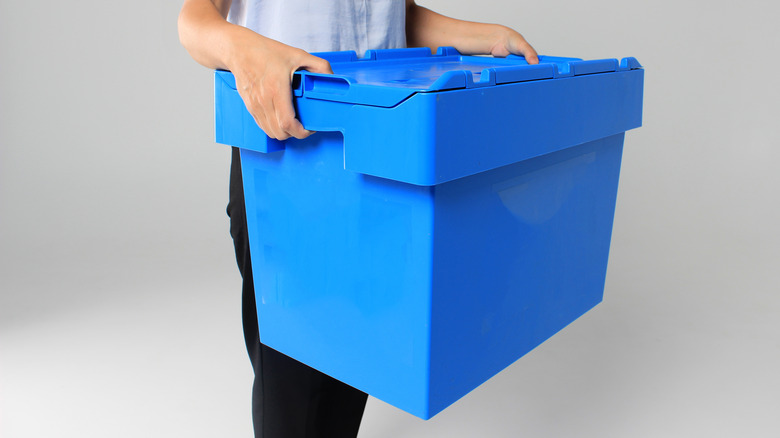 Person holding a plastic moving box