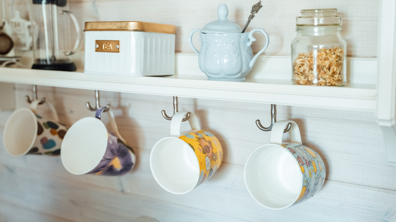 colorful mugs on metal hooks