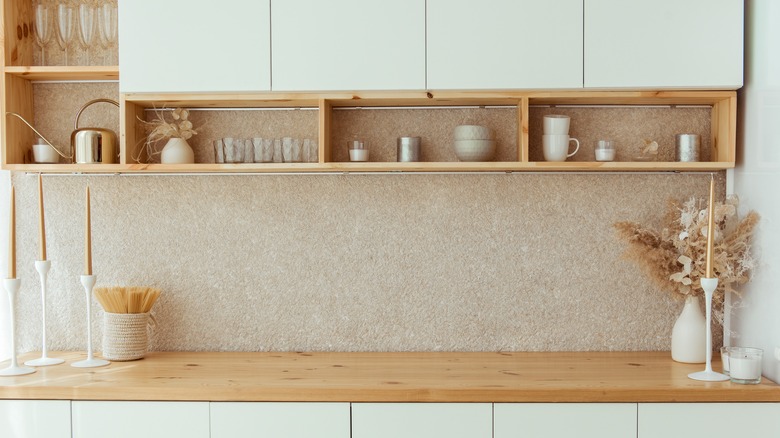 mugs in shelves below cabinets