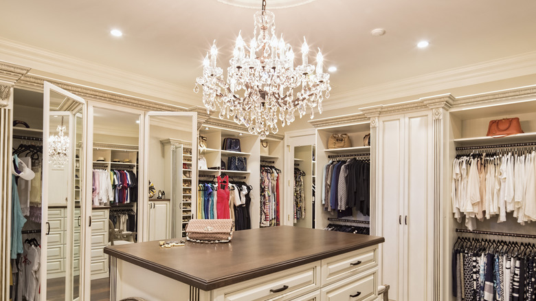 Crystal chandelier hanging over island in walk-in closet