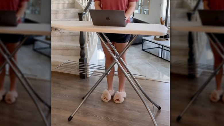 woman using ironing board as desk
