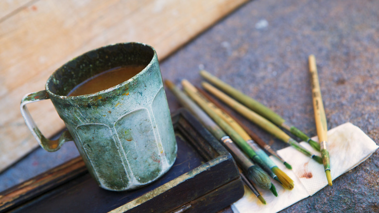 blue mug next to paintbrushes