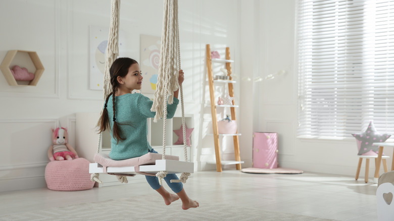 child sitting on indoor swing