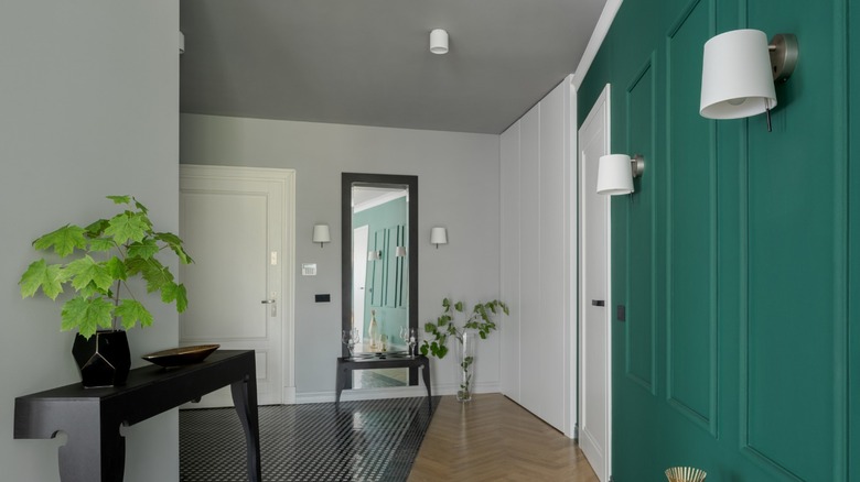 green hallway with sconces