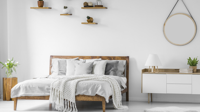 White bedroom with low and large white cabinet beside the bed