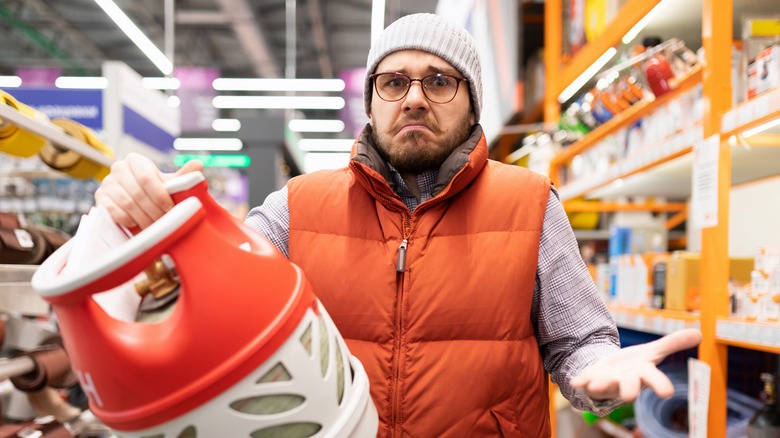 Man in hardware store shrugs