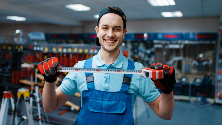 Hardware store employee with measuring tape