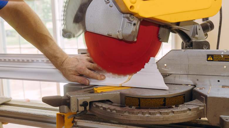 Man cutting crown molding