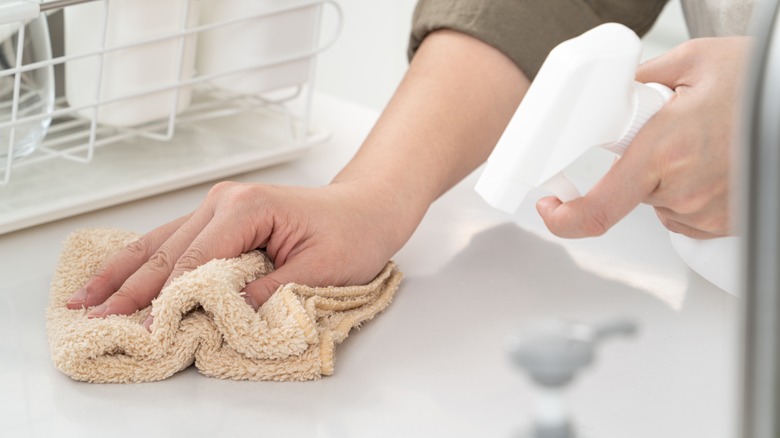 person wiping laminate countertop