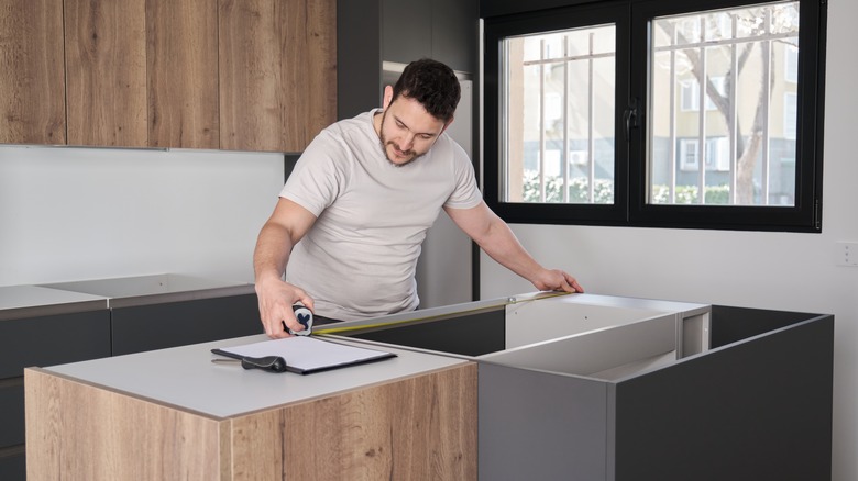 man measuring countertops for installation