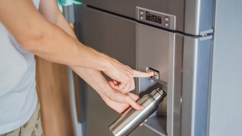 man using fridge dispenser