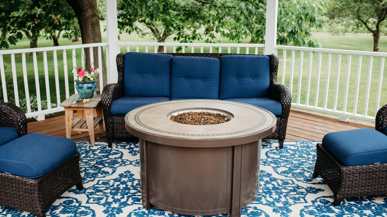 Blue outdoor furniture on top of an outdoor rug in a gazebo.