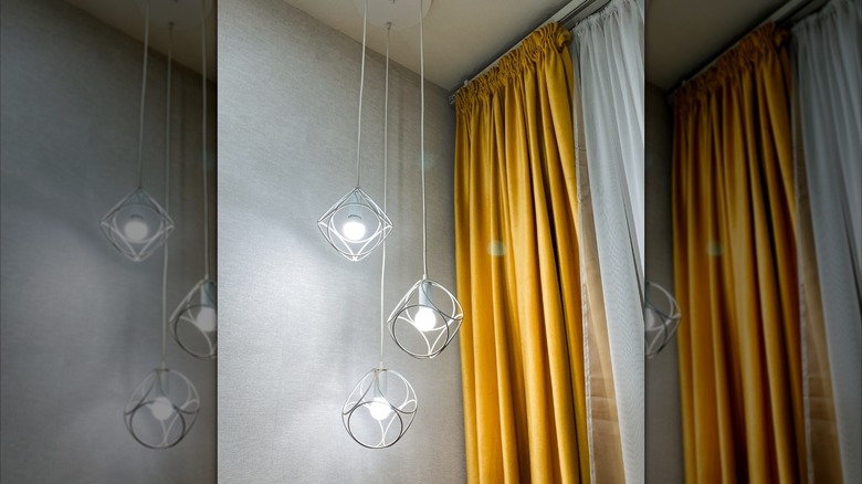 Golden yellow curtains against gray walls accented with modern pendant lighting