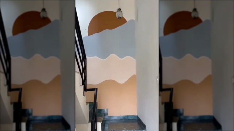 Painted sunset wall mural on staircase in a home