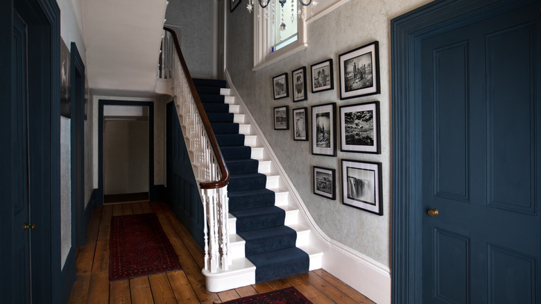 Victorian-style staircase in home with a stair runner