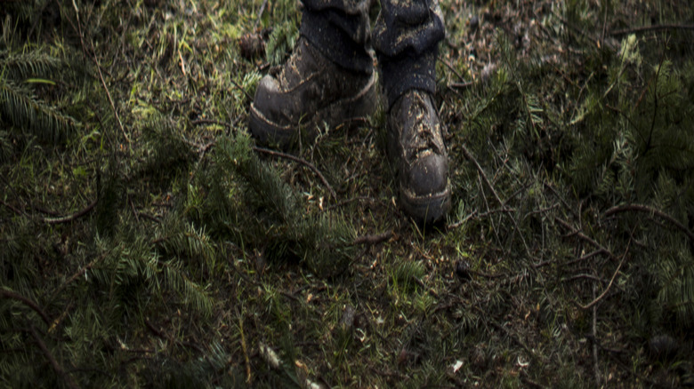 Man with gloves holding a chainsaw with both hands