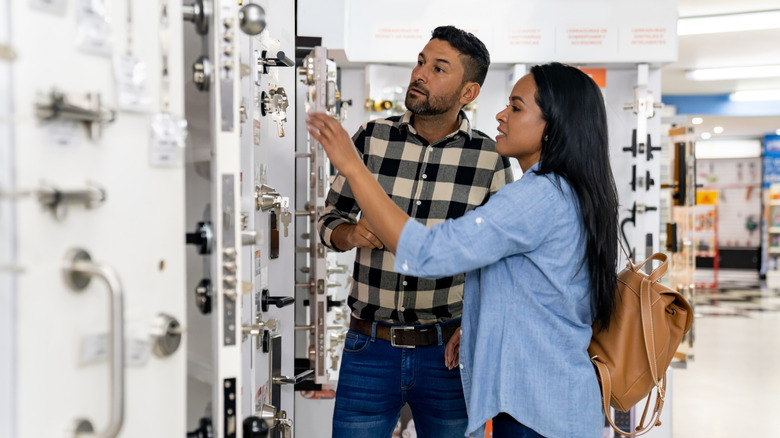 A man and a woman are shopping for cabinet hardware