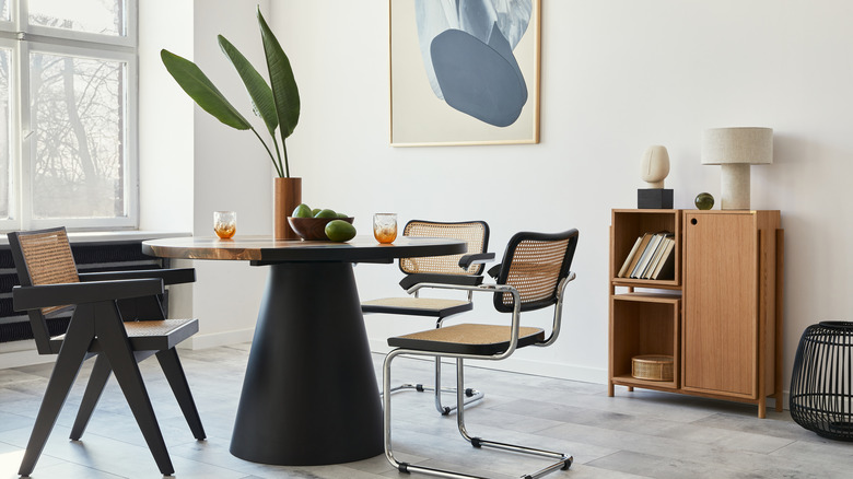 White room with gray tiled floor and black and beige table and chairs