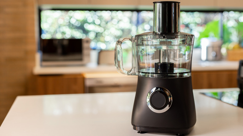 Black food processor on counter in a clutter-free kitchen